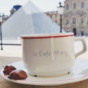 2 chocolats au café marly avec le louvre en fond